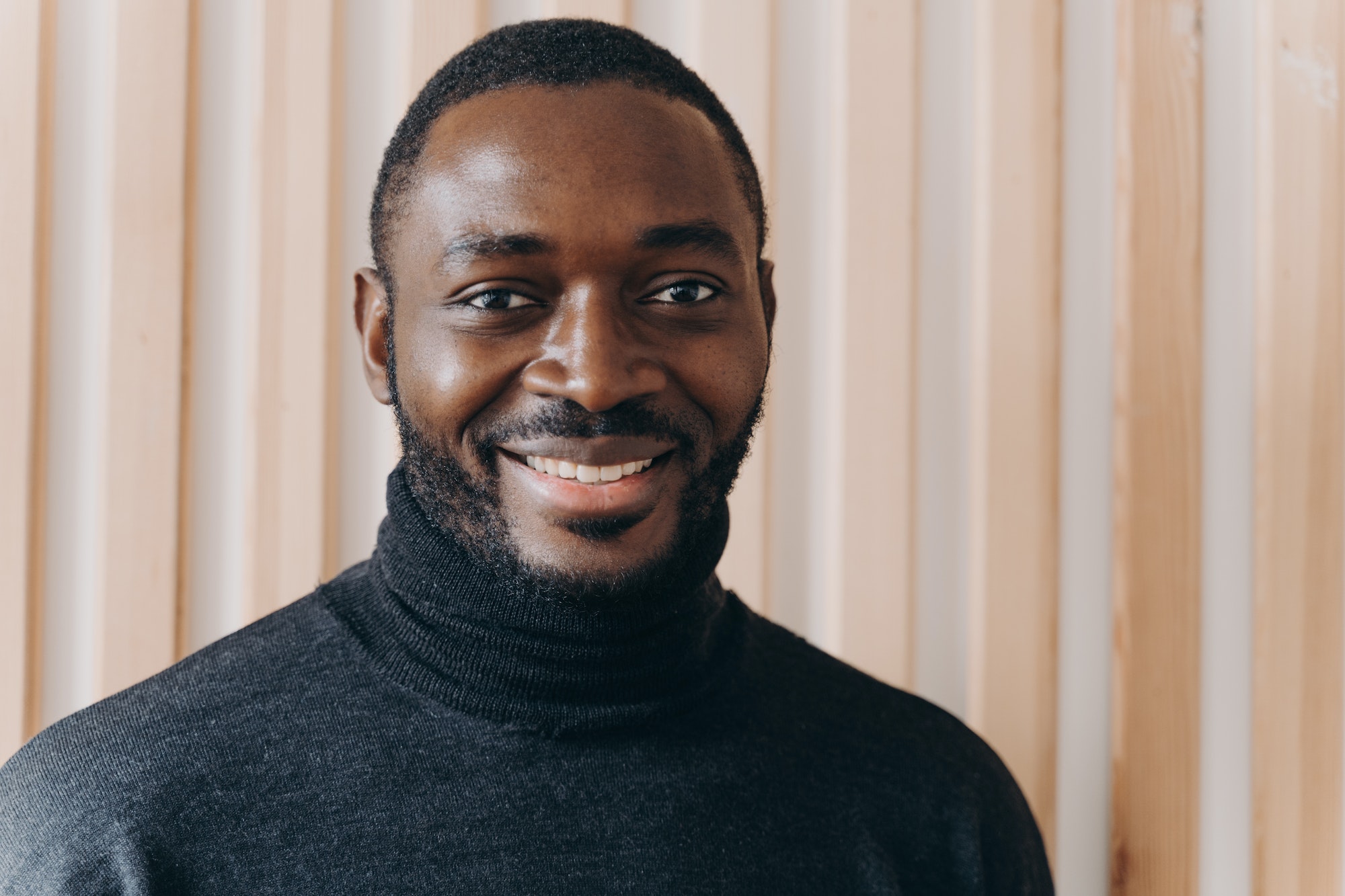 Portrait of happy cheerful african american man smiling at camera, expressing positive emotions